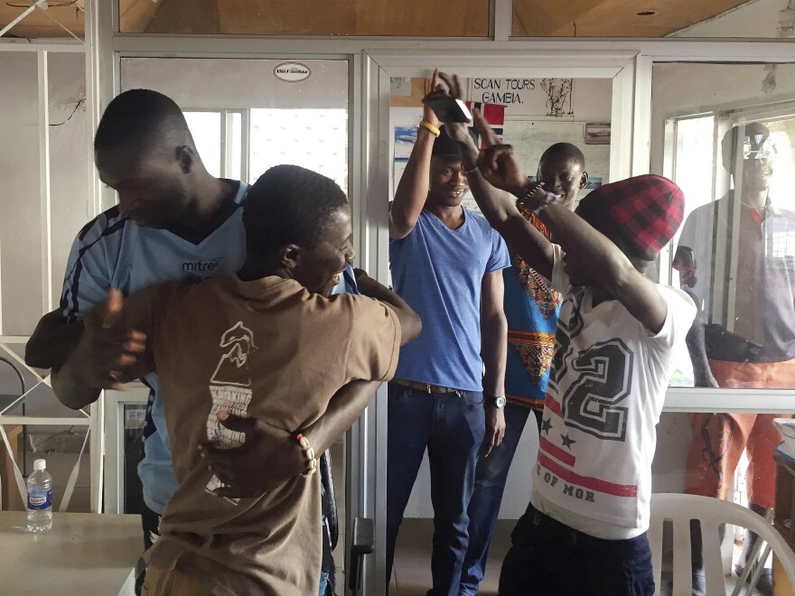 Gambians cheers in the city of Bakau on Thursday after watching a broadcast of Adama Barrow being sworn in as Gambian president at the Gambian Embassy in Dakar, Senegal.