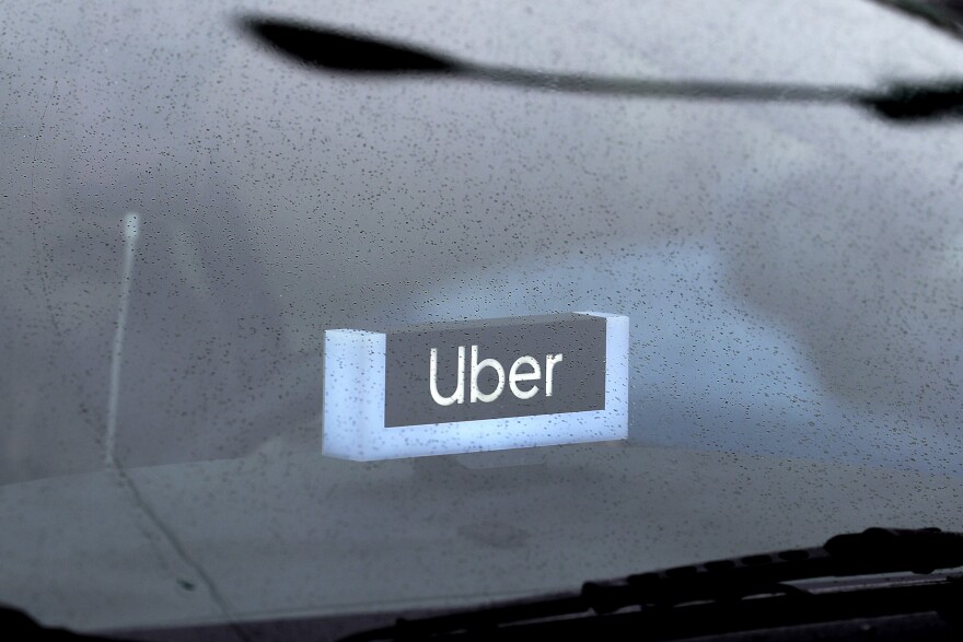 In this May 15, 2020 file photo, an Uber sign is displayed inside a car in Chicago.