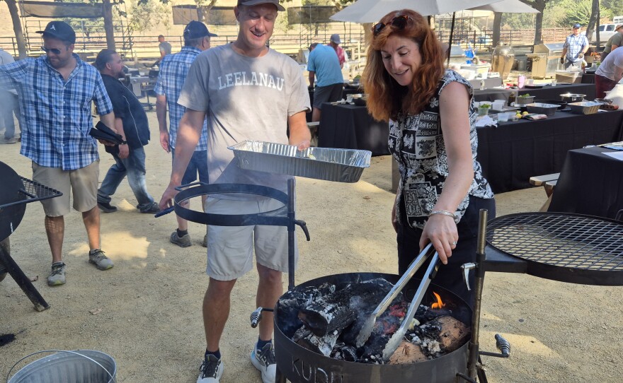 These students are using the "caveman" technique on the Kudu grill. The food goes directly onto the coals.