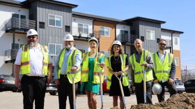 Urban system developer, city and state officials pose in front of the REO Gate Project buildings along South Washington Avenue in Lansing.