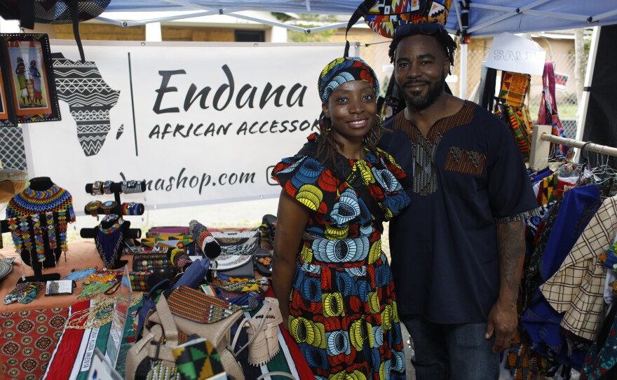 Gertrude and her Alvin Collymore pose for in front of their Endana African Accessories during the 2022 Publix Tampa Bay Collard Festival in St. Petersburg, Florida, on Saturday, February 19, 2022. Photo by Octavio Jones for WUSF