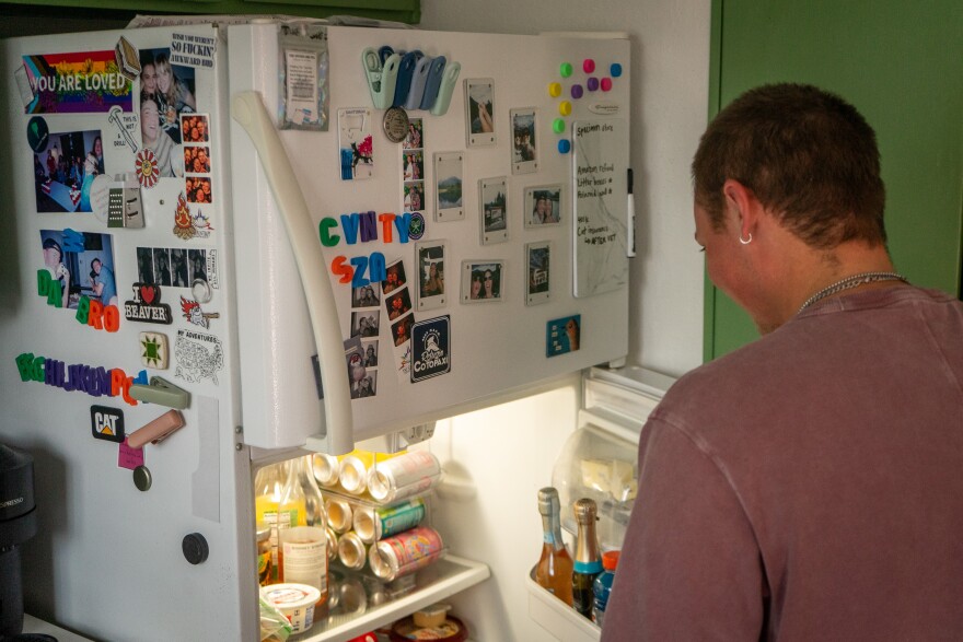 Jaxon Smith gets something out of the fridge in his kitchen. He’s owned his home since 2023.