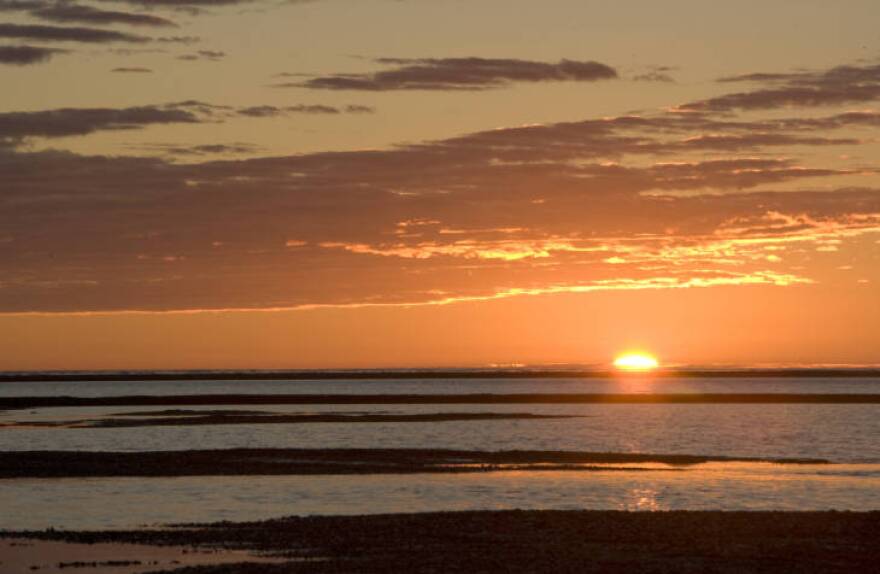 A sunset over a watery lanscape