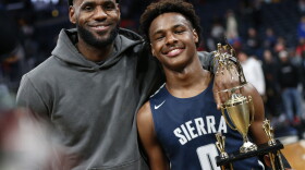 FILE - LeBron James, left, poses with his son Bronny after Sierra Canyon beat Akron St. Vincent - St. Mary in a high school basketball game, Saturday, Dec. 14, 2019, in Columbus, Ohio. Bronny James, son of NBA superstar LeBron James, was hospitalized after going into cardiac arrest while participating in a practice at Southern California on Monday, July 24, 2023. (AP Photo/Jay LaPrete, File)