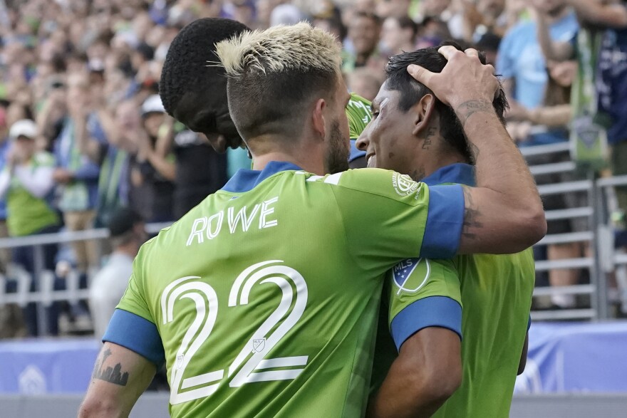 Seattle Sounders' Kelyn Rowe greets Raul Ruidiaz, right, after Ruidiaz scored a goal against the Houston Dynamo during the second half of an MLS soccer match Wednesday. 