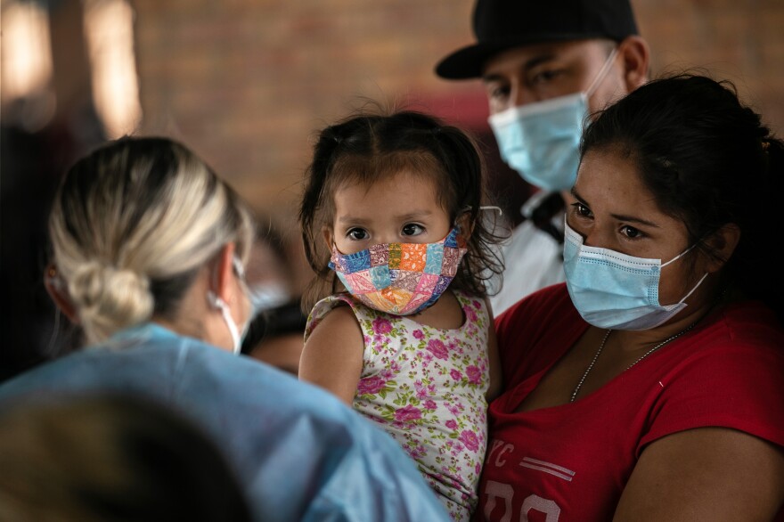 An immigrant mother holds her daughter while awaiting Covid-19 test results on last month after being released by U.S. immigration authorities in Brownsville, Texas.