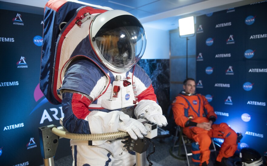 The two NASA spacesuit prototypes, one for exploring the surface of the moon's South Pole (left) and one for launch and reentry aboard the agency's Orion spacecraft, won't become a reality in time for a planned 2024 mission. [Kevin Wolf / AP]