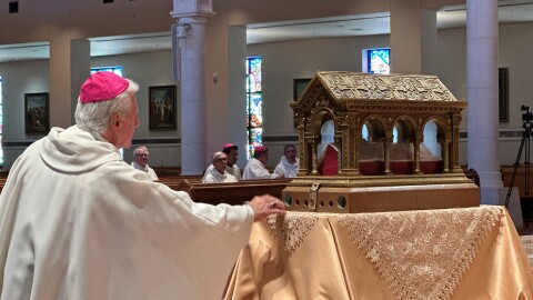 A bishop venerates relics of the 17th century St. Mary Margaret Alacoque, a French nun whose reports of visions of Jesus has led to the modern devotion of the Sacred Heart of Jesus, in front of the Basilica of the National Shrine of Mary, Queen of the Universe in Orlando, Fla., before a service Thursday, June 11, 2026, in which U.S. Catholic bishops consecrated the United States to the Sacred Heart upon the nation's 250th anniversary.