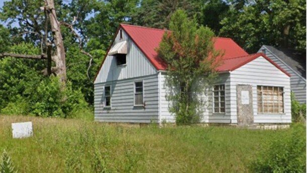 A house sits vacant and boarded up in the 1700 block of North Johnson Street in South Bend, next to a vacant, overgrown lot.