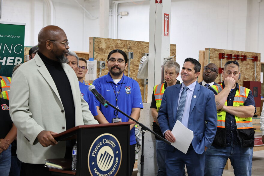 Pierce County has given Clover Park Technical College a $300,000 grant. Lester Burkes, the college’s dean of Automotive and Trades, at left, addresses a crowd at the college’s Eastside Training Center, with Pierce County Executive Ryan Mello, at right, looking on.