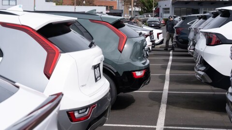 People look at vehicles at the Beaverton Kia dealership, with electric vehicles at left, on Wednesday, April 15, 2026, in Beaverton, Ore. (AP Photo/Jenny Kane)