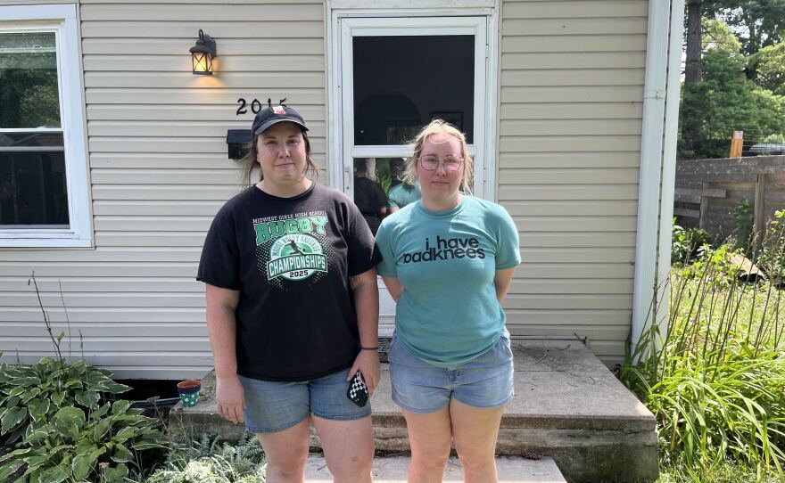Stephanie and Maisie Duncan (left to right) stand outside their rental on 67th and Evanston Sunday, Aug. 16, 2026 right outside the evacuation zone. They evacuated Saturday night after their basement flooded, and said they saw kayakers coming down the street. They're back Sunday to survey the damage, throwing out items in the garage and deciding what to do about their washer and dryer, which were destroyed.