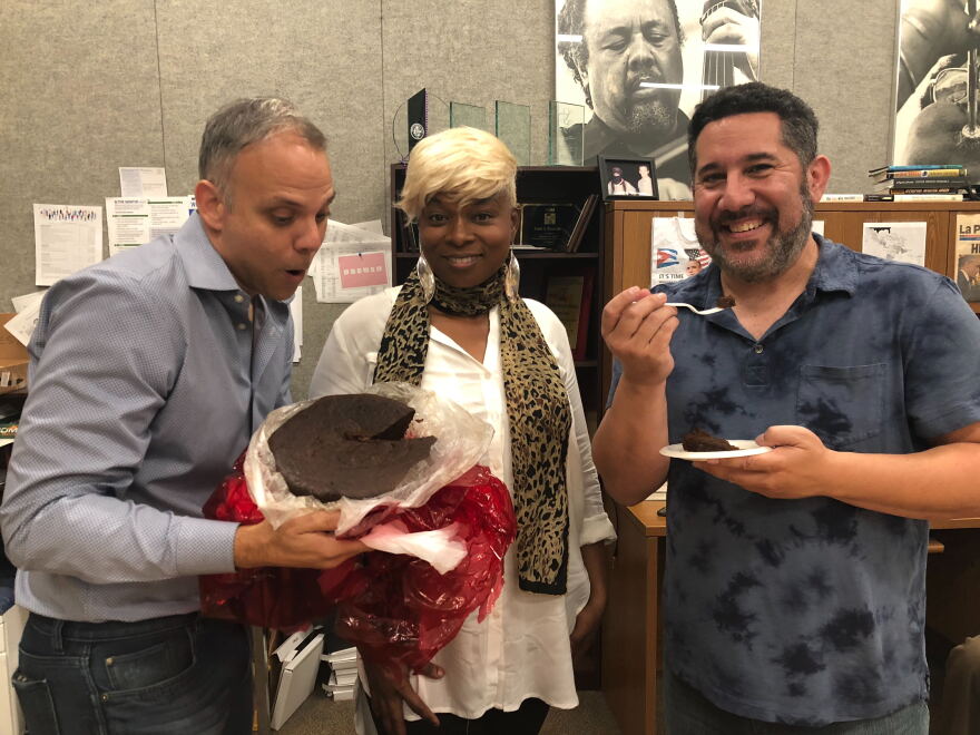 Meet our South Florida holiday food panel: Carlos Frias (left) and Kathy Ann Paul (middle). WLRN Sundial host Luis Hernandez is trying Carribean Black Cake.  