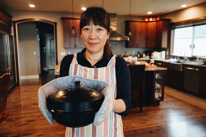 The author's mother, Jenna Cho, holding a pot of samgyetang in her home in Mercer Island, Wash.