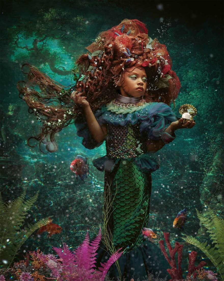 Treasures from the sea nestle in the little mermaid's rosy hair as she strikes a royal pose.