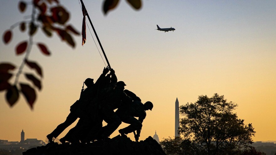 The sun rises behind the U.S. Marine Corps Iwo Jima memorial near Arlington National Cemetery in Arlington, Va.