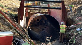 Crews in Bellingham replace an old culvert (center) with a new 12-foot diameter pipe. The old culvert was too small and sat too high for juvenile fish to navigate during their migration to their spawning grounds.