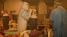 Health workers attend to COVID-19 patients inside a banquet hall temporarily converted into a covid care centre in New Delhi on April 28, 2021. (Prakash Singh/AFP via Getty Images)