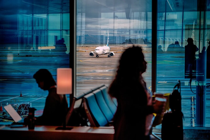 A passenger plane taxies on a water-soaked runway at San Francisco Airport while passengers wait for flights on Nov. 21, 2024.