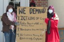 UC student protestors hold a sign listing demands for university leaders.