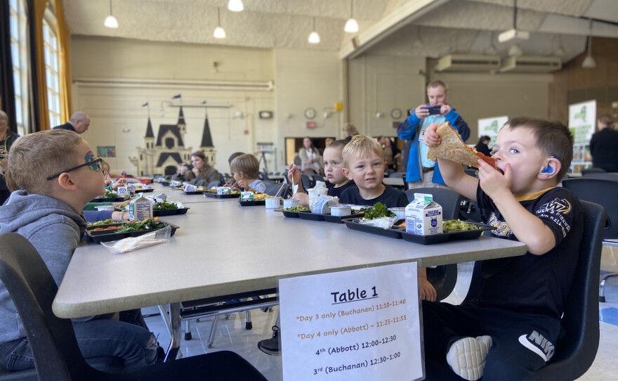 Students at C R Weeks Elementary chow down on pizza and kale salad.