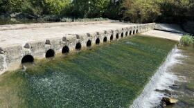 Water flows through a low-head dam.
