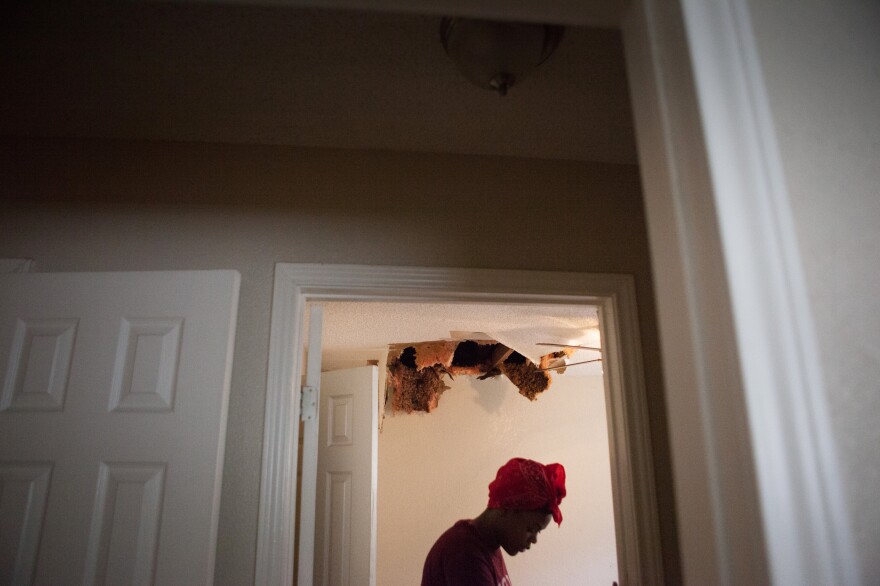 Teniya Brewer walks through Pauline Simpson's home looking at the water damage.