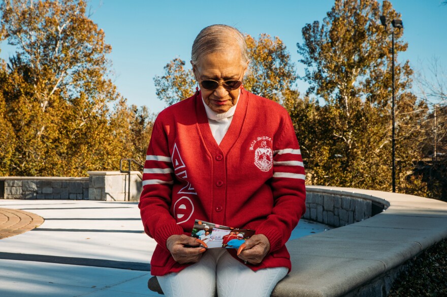 Marian Hatch, a former resident at Arbor Terrace at Cascade, looks at one of the photos of her friends. Hatch, 92, tested positive for COVID-19 but survived and was one of Mann's closest friends at the facility.