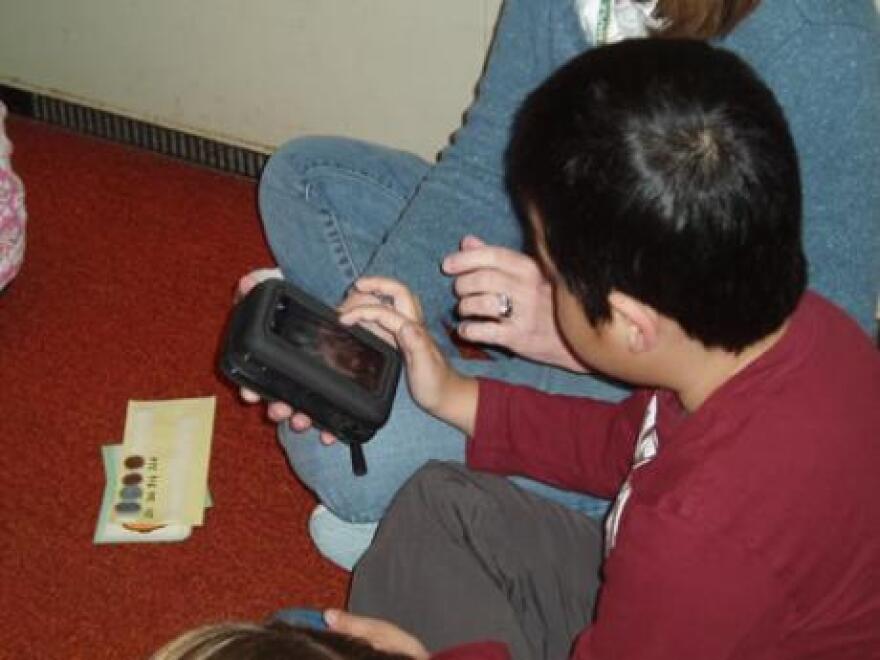 Student uses a handheld communication device. (Courtesy Laura Jenkins-Basdekis)