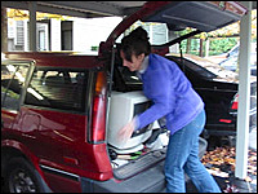 Joanna Slaybaugh packs her computer into her station wagon on moving day.