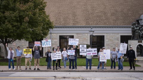 Scott County Democrats hold signs. (Chris Bentley/Here & Now)