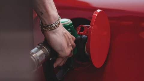 A person pumping gas into a vehicle.
