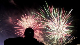 A man watches fireworks after a baseball game between the Kansas City Royals and the Los Angeles Angels Friday, June 16, 2023, in Kansas City, Mo. The Angels won 3-0. (AP Photo/Charlie Riedel)