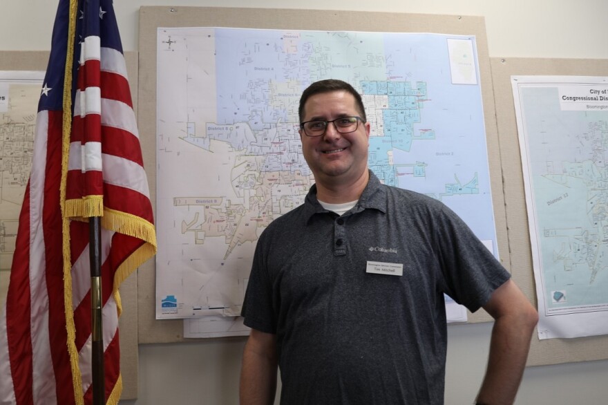 Tim Mitchell standing next to American flag