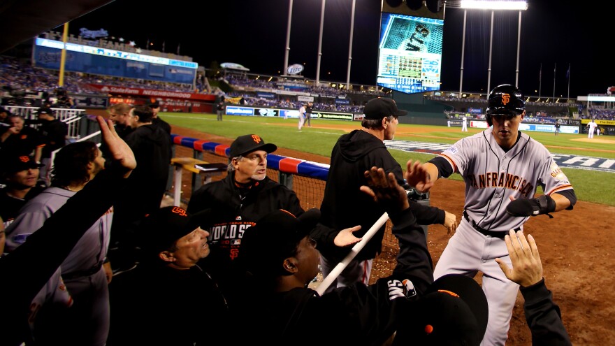 Microphones line the dugout, catching the sound of celebrations like this one by the Giants, after second baseman Joe Panik's seventh-inning score in Game 1.