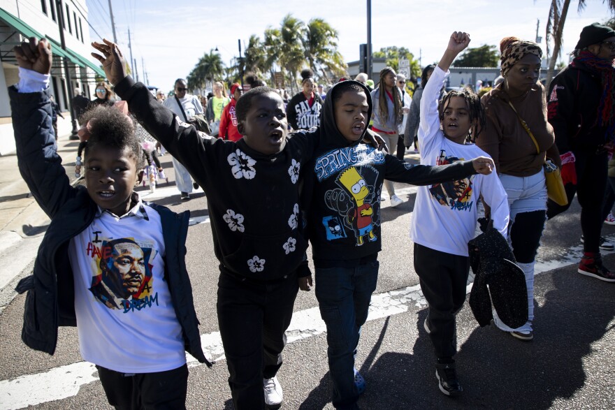 Journey Holloway, left, Mason Holloway, Lorenzo Jones and Louis Moss chant while marching in the Dr. Martin Luther King Jr. Annual Commemorative March on Monday, Jan 19, 2026, in Fort Myers.