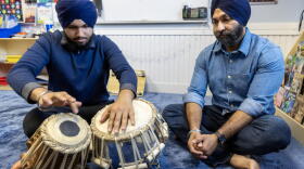 Talvinder Singh watches as his son, Ranveer, plays the tabla at the Gurdwara Guru Nanak Darbar in Medford, Mass. (Robin Lubbock/WBUR)