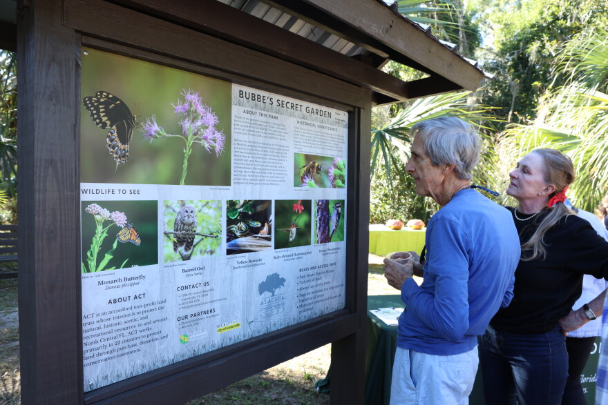 Gainesville residents read informational sign at Alachua Conservation Trust’s grand opening of Bubbe’s Secret Garden in Gainesville, FL, Nov 17, 2024.
