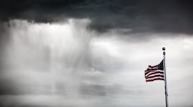 American flag flying during a rain storm.