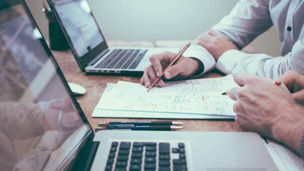 image of people working, people handling paperwork, and using laptops.
