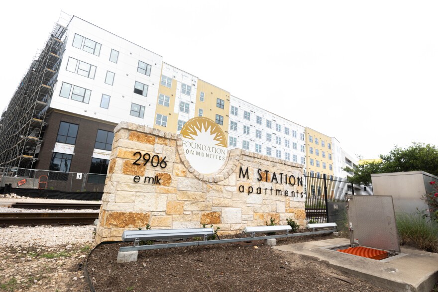 A sign in front of a building identifying M Station Apartments