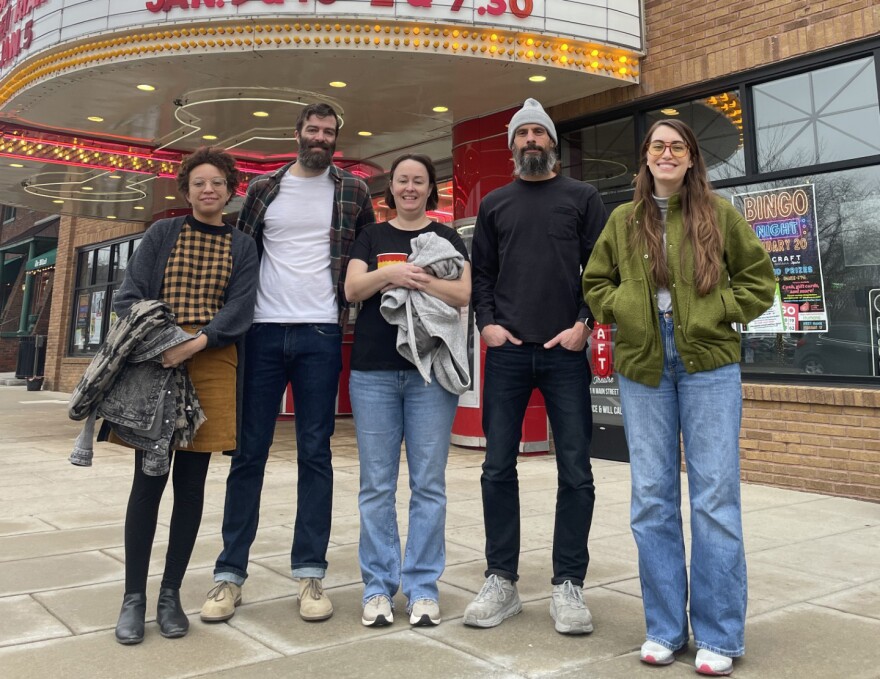 Five people standing in front of an old-fashioned theatre