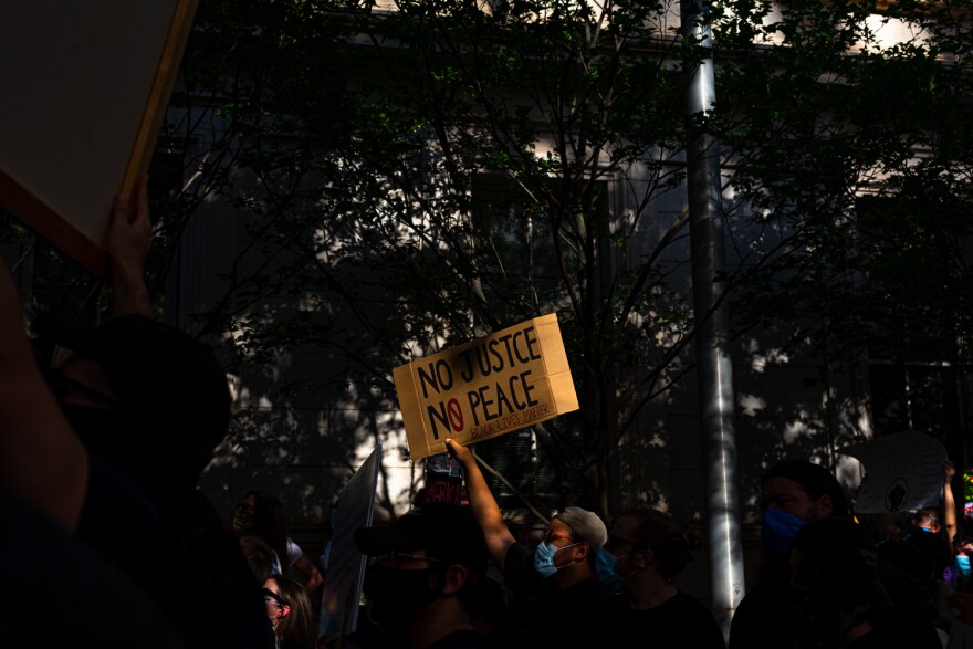 File photo of protesters walking through downtown Raleigh holding signs calling for justice after the killing of George Floyd, who died in Minneapolis earlier in the week.