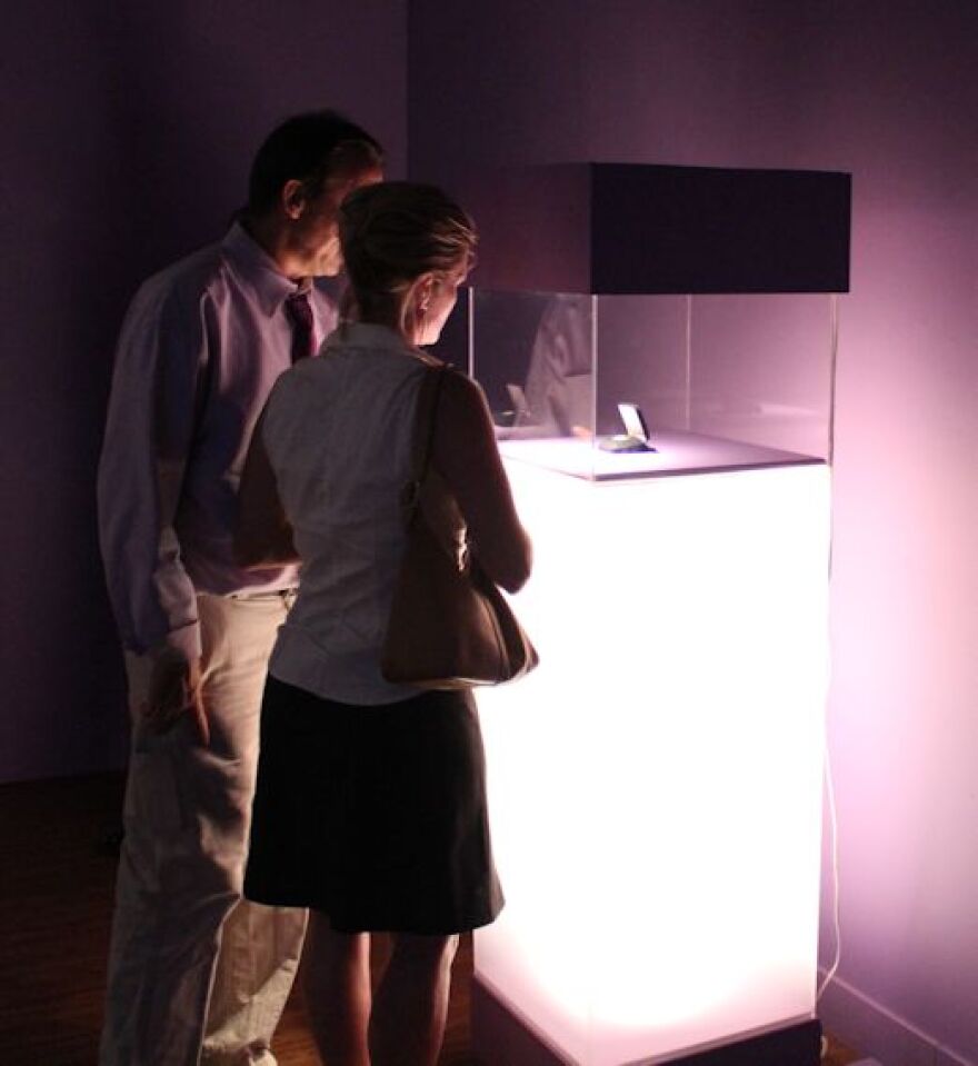 Guests view Moon Museum chip during 2014 exhibition at the Bob Rauschenberg Gallery.