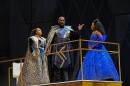 two women and one man stand on a stage in costume