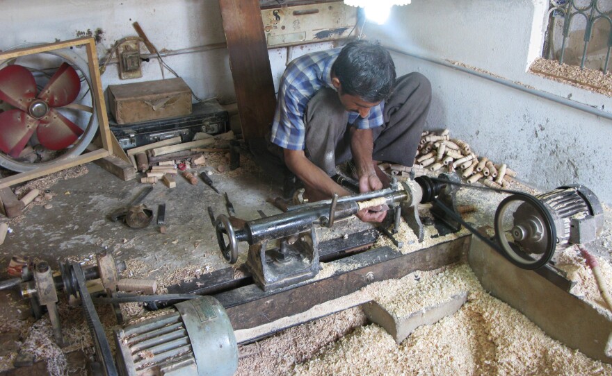 A lathe operator in the workshop of Halifax and Company turns out wood spindles that will be part of the pipes in toy bagpipes.