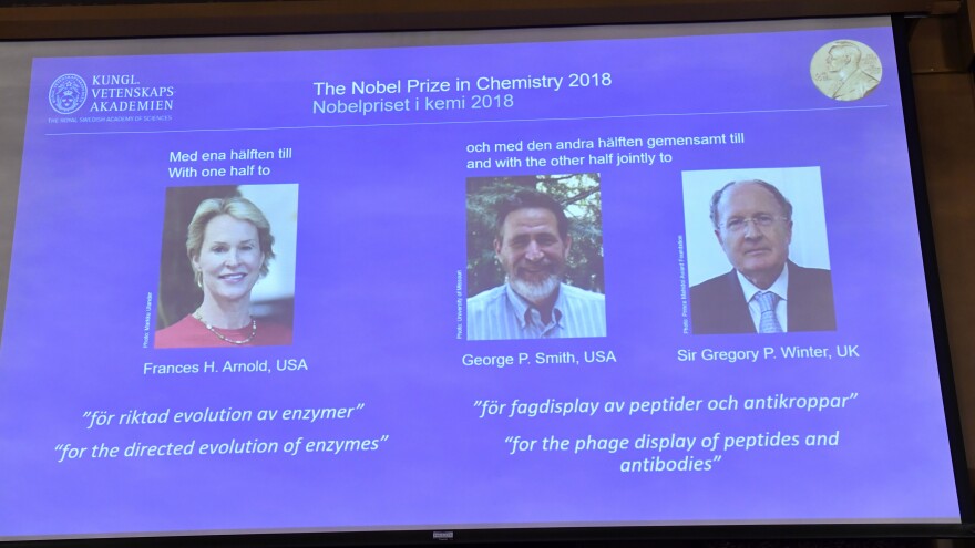 A screen displays portraits of Frances Arnold of the United States, George Smith of the United States and Gregory Winter of the U.K. during the announcement of the winners of the 2018 Nobel Prize in chemistry at the Royal Swedish Academy of Sciences on Wednesday.