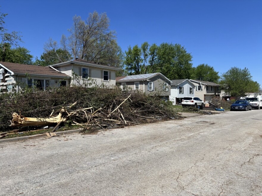 A view of debris stacked up on a residential street after a storm