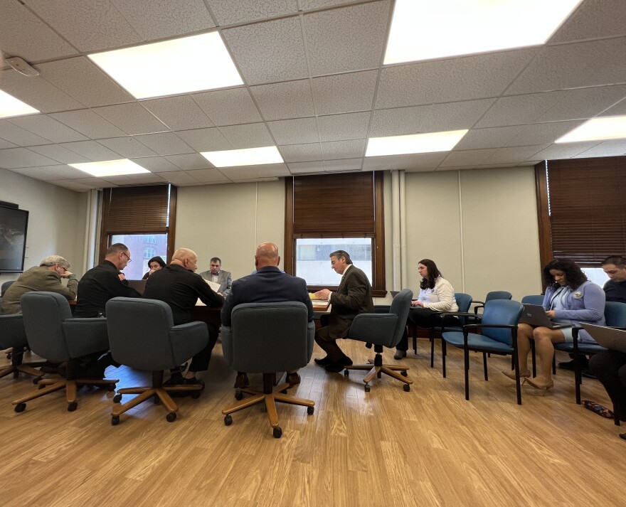 Representatives from the Springfield, Massachusetts, Fire Department huddle with Mayor Domenic Sarno (head of table) and other city officials during a budget hearing on March 30, 2023. 