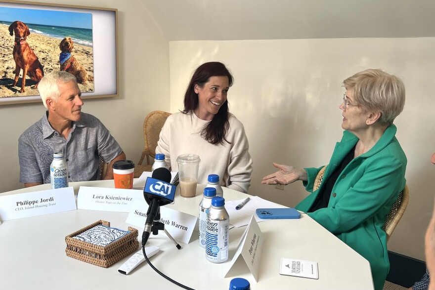 Sen. Elizabeth Warren, right, talks with Philippe Jordi, CEO of Island Housing Trust, left, and Lora Ksieniewicz, owner of Yoga on the Vine. They were part of a community roundtable Warren hosted at the Martha's Vineyard Chamber of Commerce in Vineyard Haven, about the difficult housing climate on the Vineyard. Aug. 14, 2026.